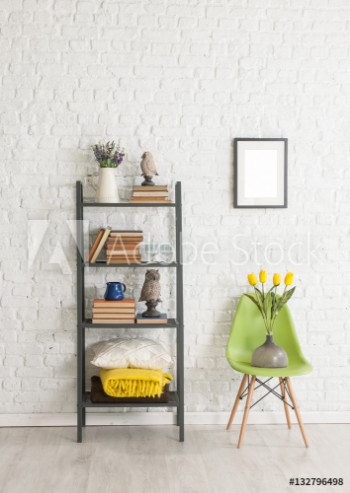 Picture of bookcase and many books concept with brick wall and green chair